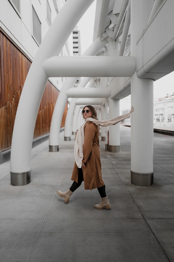 A woman walking through a colonnade of identical white columns